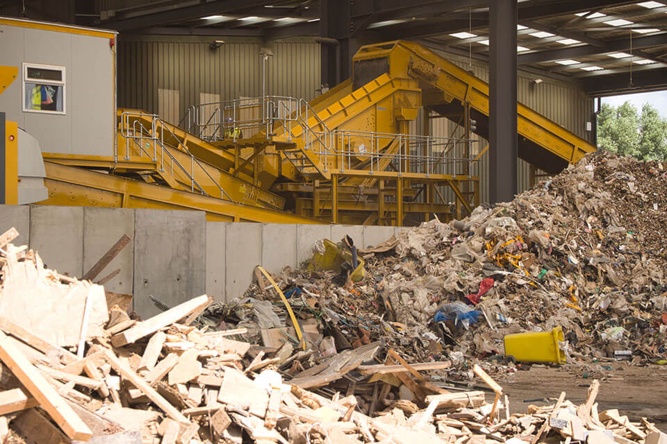Blick auf eine SPALECK Siebmaschine in einer Recyclinganlage für Baumischabfälle. Im Vordergrund sieht man das Inputmaterial.